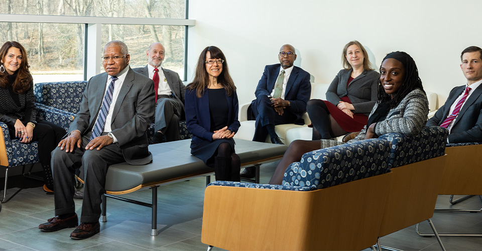 group of people sitting in a room smiling, dressed professionally